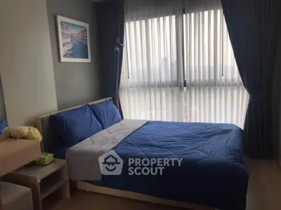 Cozy bedroom with large window and blue bedding in modern apartment