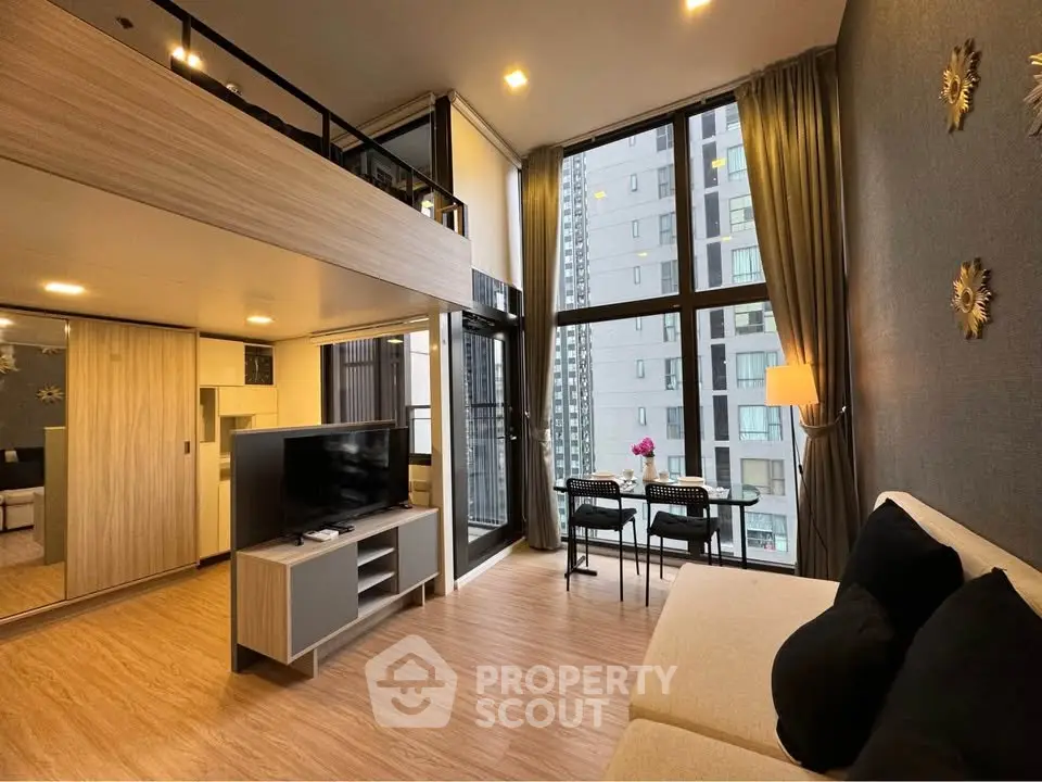 Modern loft-style living room with high ceilings and large windows offering city views.