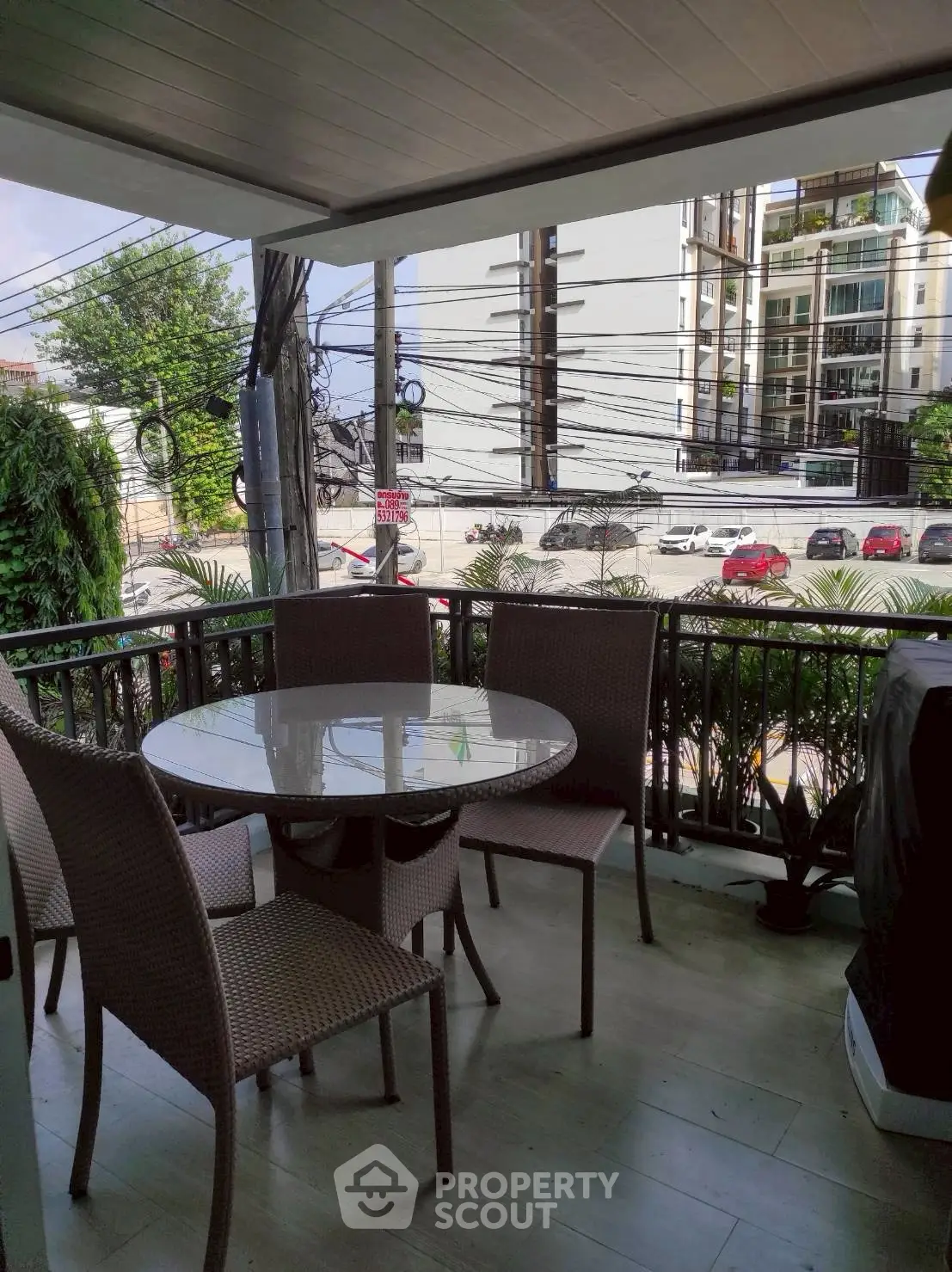 Charming balcony with outdoor dining set and city view, perfect for relaxation.