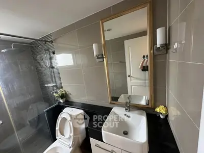 Modern bathroom with sleek fixtures and elegant mirror in a stylish apartment.