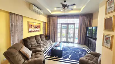Spacious living room with plush seating and modern decor, featuring large windows and elegant lighting.