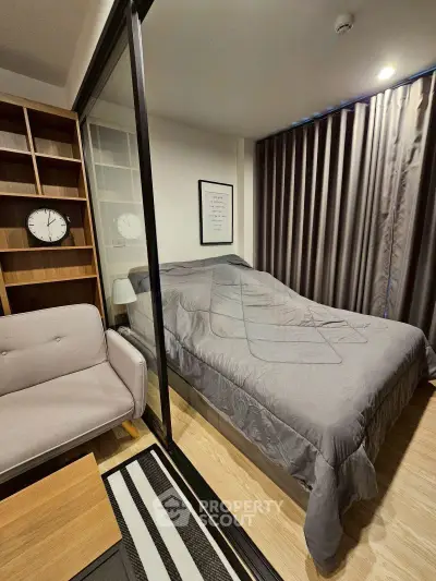 Cozy bedroom with modern decor and glass partition, featuring a comfortable bed and stylish shelving.