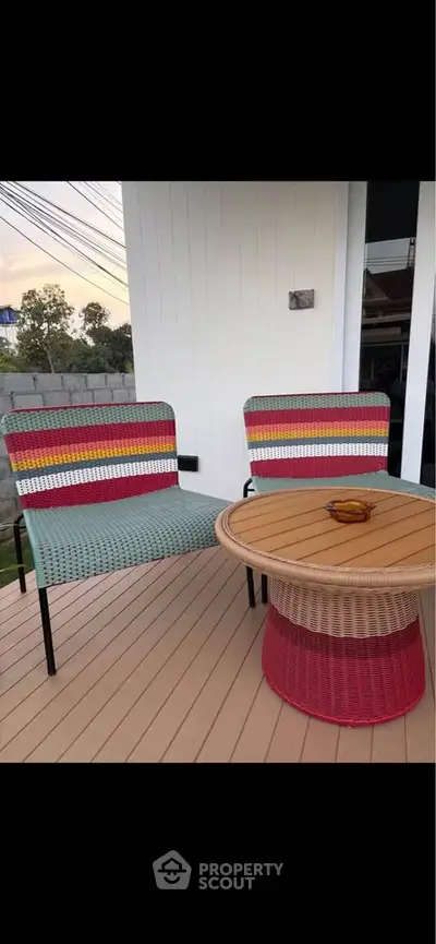 Charming outdoor patio with colorful chairs and a stylish table, perfect for relaxation and entertaining.