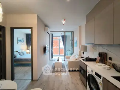 Modern apartment interior with open kitchen, cozy living area, and bedroom view, featuring stylish decor and natural light.