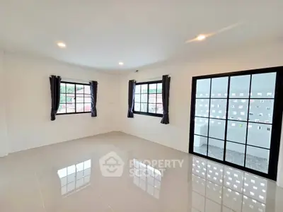 Spacious modern living room with large windows and glossy tiled floor