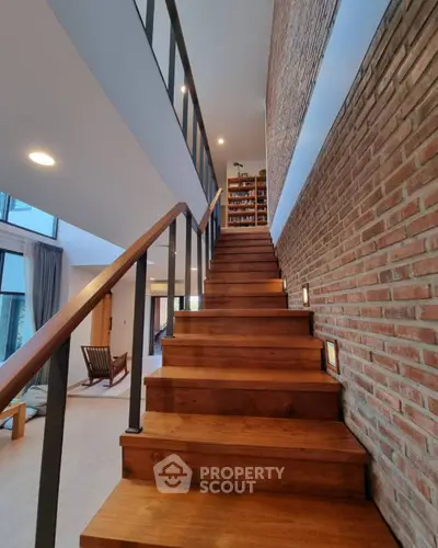 Elegant wooden staircase with brick accent wall in modern home interior