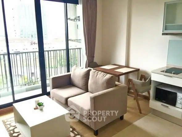 Modern living room with cozy sofa, dining area, and balcony view in a stylish apartment.