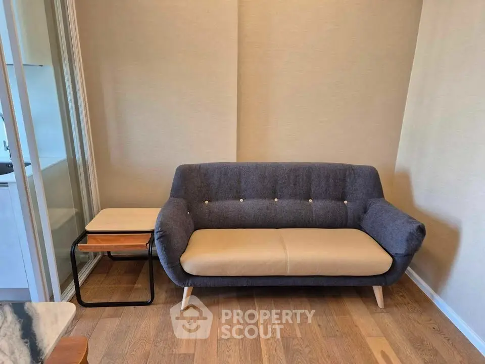 Cozy living room with modern sofa and wooden flooring, perfect for relaxation.