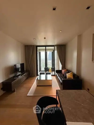 Modern living room with sleek furniture and city view from large windows.