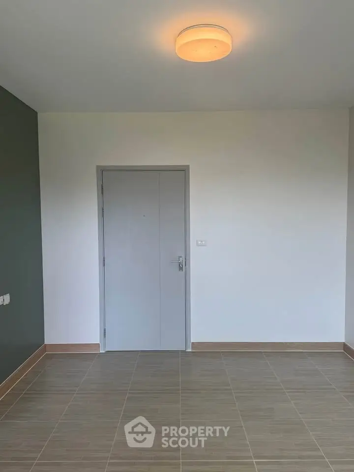 Minimalist empty room with tiled floor and modern lighting, perfect for customization.