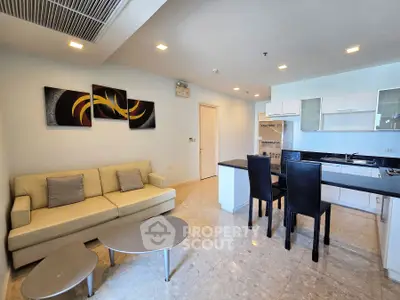 Modern open-layout living room and kitchen with stylish decor and sleek furniture.
