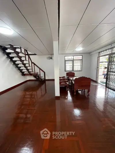 Spacious living room with wooden flooring and staircase in a modern home