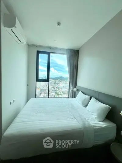 Modern bedroom with large window offering stunning city view, featuring a comfortable bed and minimalist decor.