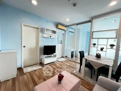 Modern living room with dining area, featuring wooden flooring and stylish decor.