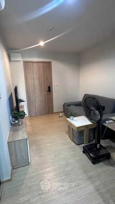 Modern living room with sleek furniture and wooden flooring, perfect for cozy urban living.