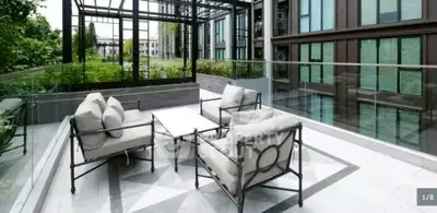 Luxurious balcony with modern outdoor seating and lush greenery view.