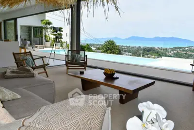 Luxurious living room with panoramic ocean view and infinity pool, featuring modern decor and cozy seating.