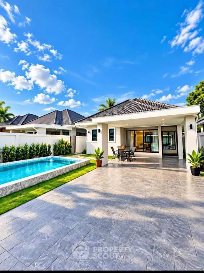 Stunning modern villa with private pool and spacious patio under a clear blue sky.