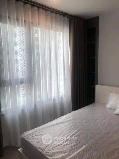 Cozy bedroom with large window and elegant curtains in modern apartment