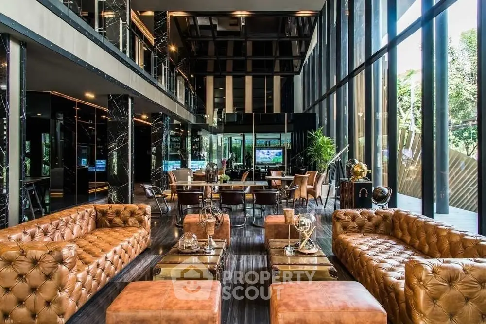 Luxurious modern living room with leather sofas and floor-to-ceiling windows offering stunning views.