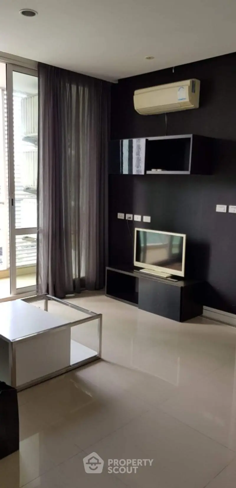 Modern living room with sleek black furniture and large window for natural light.