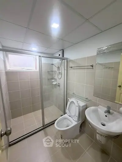 Modern bathroom with glass shower enclosure and sleek fixtures