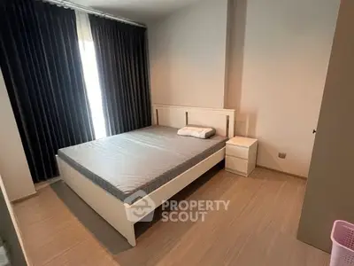 Spacious bedroom with modern design and natural light, featuring a comfortable bed and stylish decor.