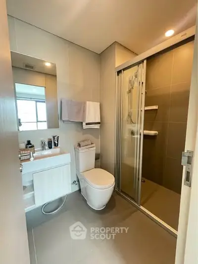 Modern bathroom with glass shower and sleek fixtures in a contemporary apartment.