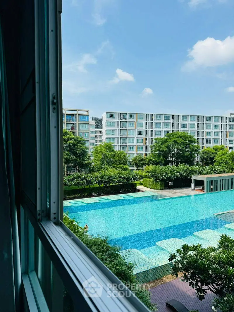 Stunning pool view from apartment window in modern residential complex.