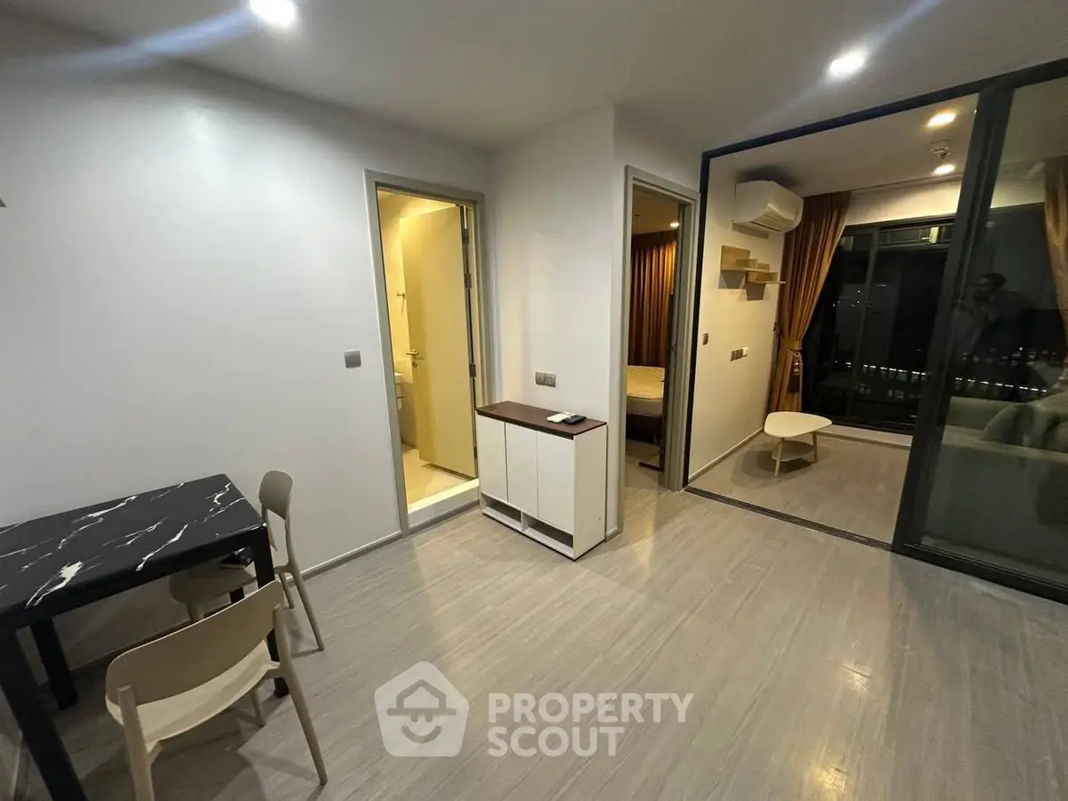 Modern apartment interior with open layout, featuring a cozy living area and sleek dining space.