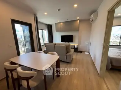 Modern living room with city view, featuring stylish furniture and open layout.