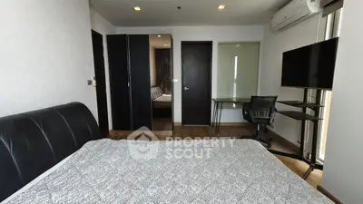 Modern bedroom with sleek furniture and workspace in a stylish apartment