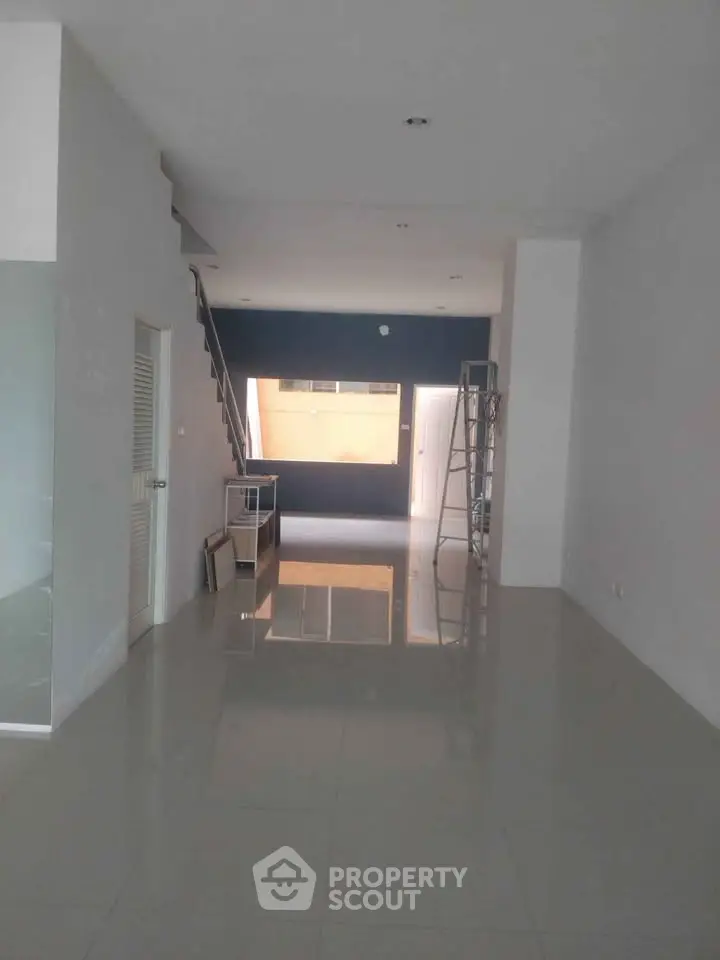 Spacious modern interior with sleek staircase and glossy tiled flooring, ideal for contemporary living.