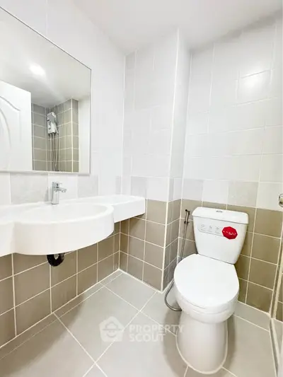Modern bathroom with sleek white fixtures and neutral tile design