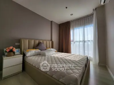 Cozy bedroom with large window and modern decor in a stylish apartment.