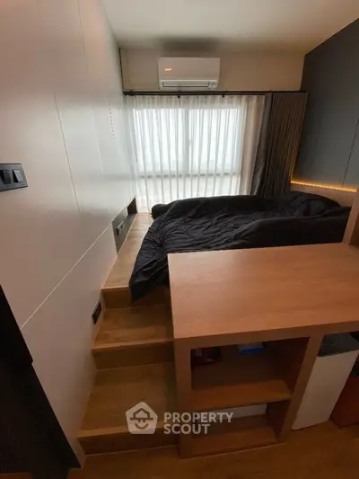 Modern compact bedroom with elevated bed and wooden accents