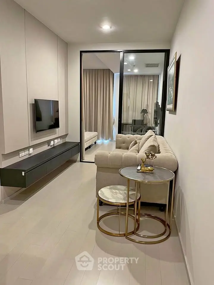 Modern living room with sleek design, featuring a cozy sofa, wall-mounted TV, and elegant decor.