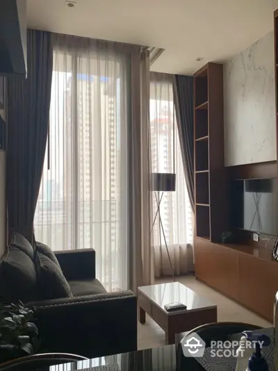 Elegant living room with floor-to-ceiling windows draped in sheer curtains, modern furniture, and a sophisticated neutral color palette.