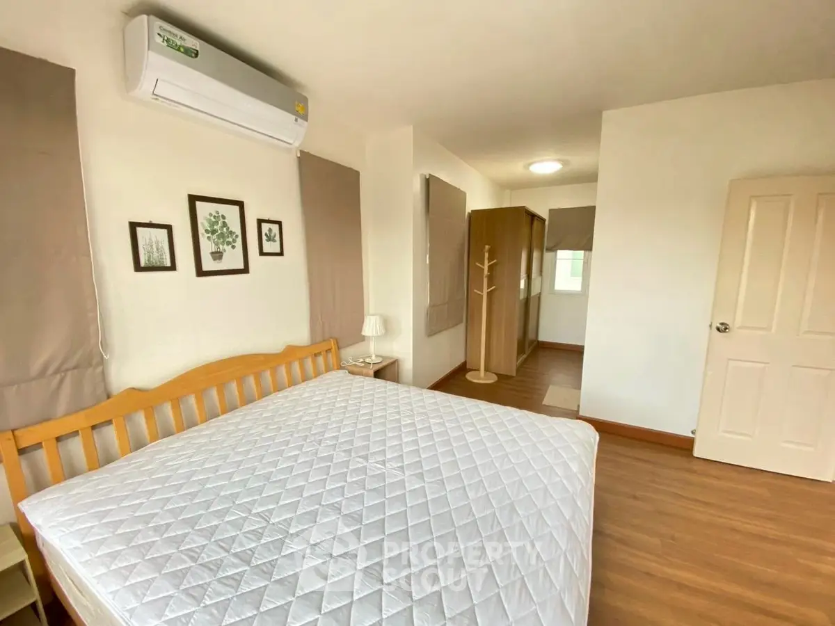 Spacious bedroom with wooden flooring and modern decor