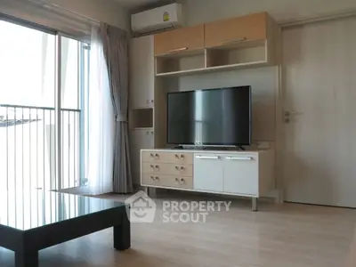 Modern living room with sleek TV stand and large window balcony view.