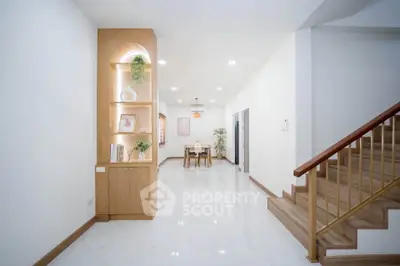 Spacious modern living area with elegant staircase and built-in shelving