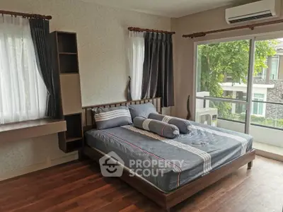 Spacious bedroom with large windows and modern decor in a stylish home.
