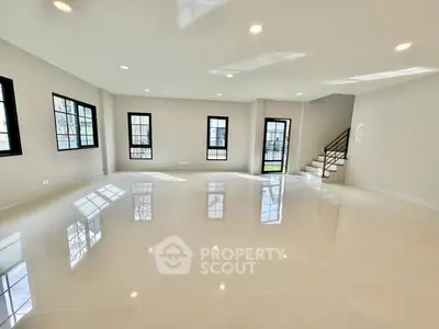 Spacious modern living room with glossy floors and ample natural light.