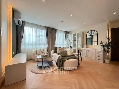 Elegant living room with modern furniture and large windows, perfect for relaxation and entertaining.