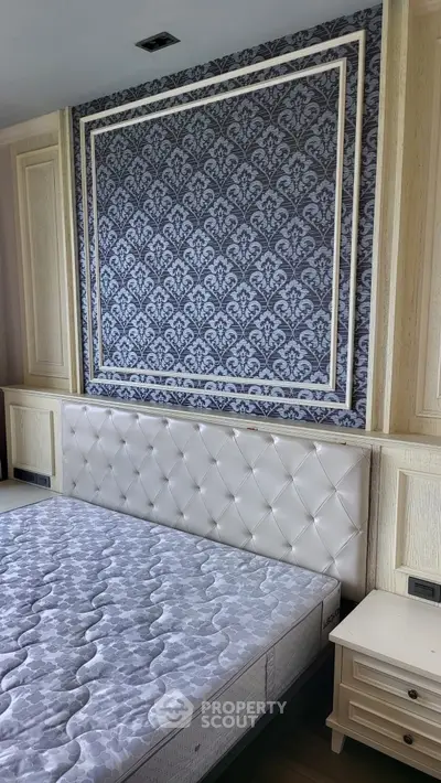 Luxurious bedroom with elegant wallpaper and plush headboard