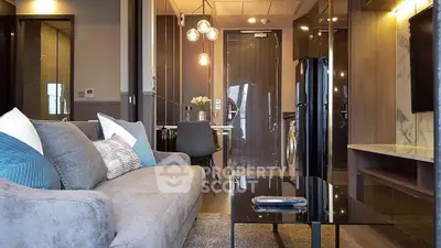 Modern living room with stylish decor and open layout, featuring a cozy sofa and elegant lighting.