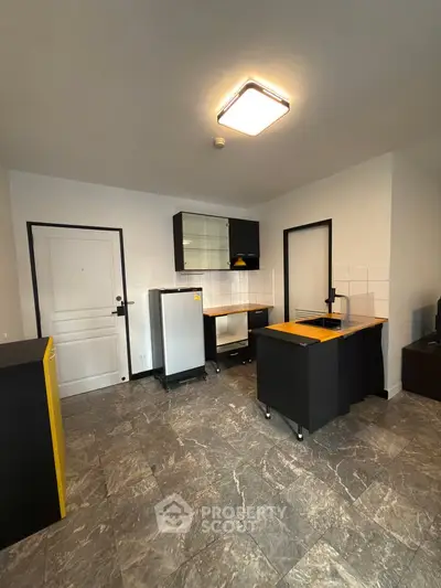 Modern kitchen with sleek black cabinets and marble flooring