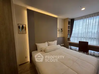 Modern bedroom with elegant decor and large window offering natural light.