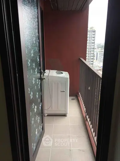 Compact balcony with washing machine and city view, ideal for urban living convenience.