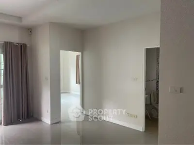 Spacious empty room with natural light and tiled flooring, ready for customization.